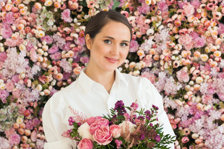 Nice stylish woman holds flower gift, holiday portraitの写真素材