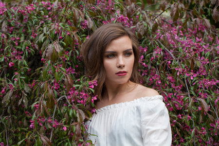 Pretty healthy woman posing outdoor in spring park, closeup portrait