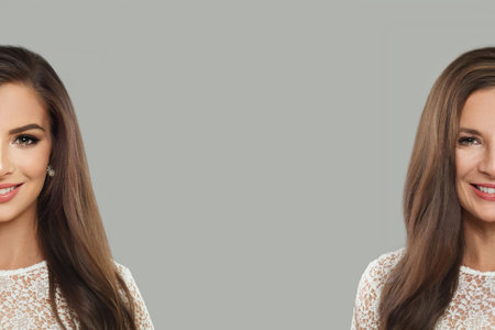 Two female generation. Young and senior woman looking at camera on gray backgroundの写真素材