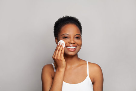 Happy healthy woman with fresh skin holding white cotton pad in her hand. Medicine, treatment and skin cleansing conceptの写真素材