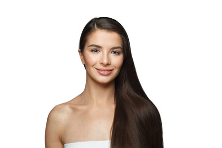 Isolated young female model with healthy hair, makeup and shiny clear skin posing against gray studio wall background. Facial treatment, cosmetology, hair care and beauty woman conceptの写真素材