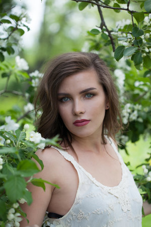 Charming lady female model in spring leaves backgroundの写真素材