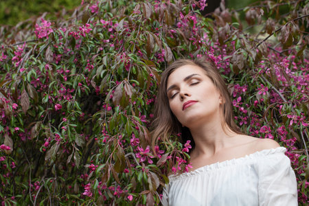 Relaxing lady female model in spring leaves backgroundの写真素材