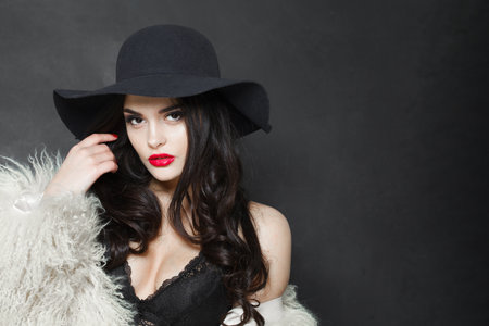 Sensuality young adult woman fashion model with bright make-up and long wavy hair wearing blue hat...