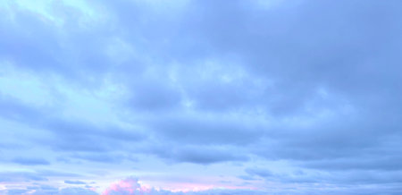Dawn sky background. Windy sky cloud and pink morning sunlightの写真素材