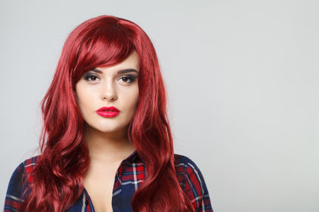 Attractive woman with beautiful long curly red hair on white backgroundの写真素材