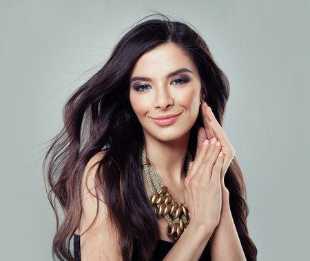 Fashion portrait of young beautiful woman with jewelry. Brunette model. Perfect make-up. Beauty style woman with gold accessoriesの写真素材