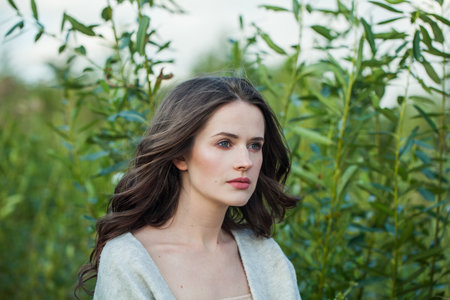 Young adult healthy brunette woman with long hairstyle and fresh skin walking outdoorsの写真素材