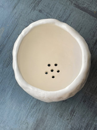 Top view of white handmade glaze ceramic flowerpot on blue background. Empty pot for gardeningの写真素材