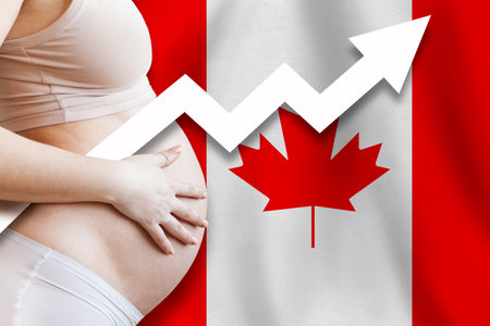 Demographics and pregnancy in Canada concept. Close-up of pregnant woman belly against Canadian Flag background.の写真素材