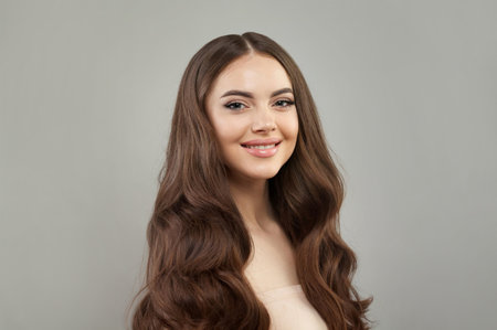 Smiling happy young female model with natural make-up, shiny clean skin and perfect hair. Beautiful woman faceの写真素材