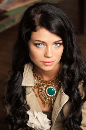 Charming young adult woman with long wavy hair and make-up fashion portraitの写真素材