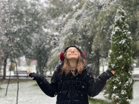 Excited little child girl laughing, walking and enjoying in the snow, outdoor winter portraitの写真素材