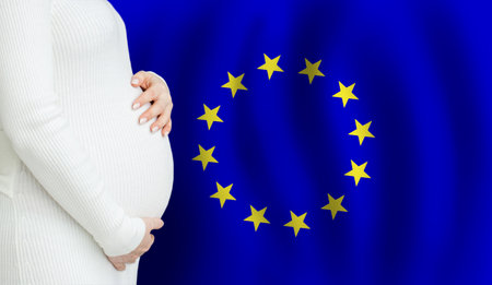 Pregnant woman belly against European Union flag background. Demographics and pregnancy in EU conceptの写真素材