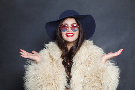 Fashion model woman in blue classic hat and white fur coat posing indoor, elegance fashion beauty portraitの写真素材