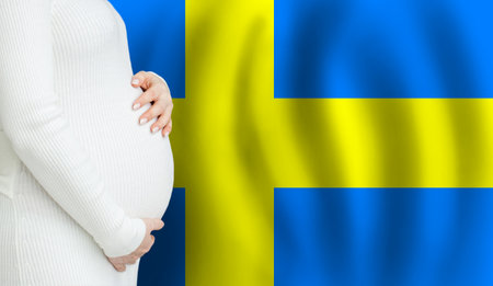 Swedish pregnant woman belly against Swedish flag background. Demographics and pregnancy in Sweden conceptの写真素材