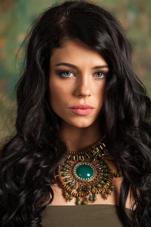 Glamorous young adult woman with long wavy hair and make-up fashion portraitの写真素材