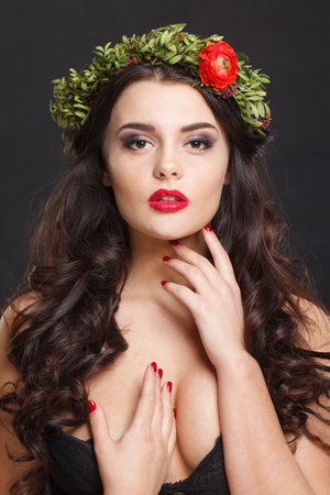 Pretty healthy female model with shiny hair, make-up and spring flower on black backgroundの写真素材