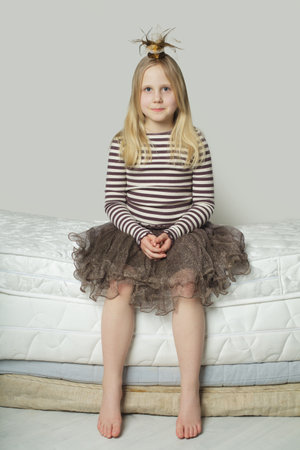Beautiful blonde child girl dreaming, indoor portraitの写真素材