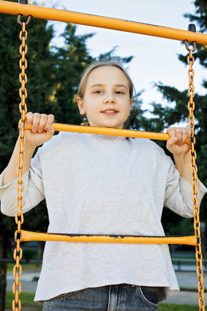 Young child girl on playground. Kids play outdoor. Childhood, happiness and leisure activity concept