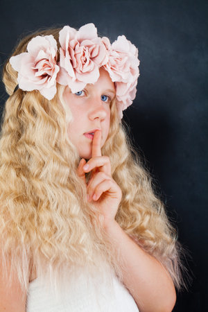 Portrait of a beautiful girl with her finger on her lipsの写真素材