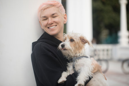 Owner woman having fun playing with pet dog outdoorsの写真素材