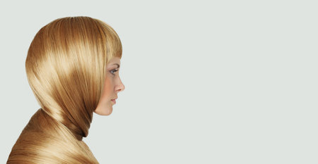 Blond young adult woman with perfect hairstyle and make-up fashion beauty portraitの写真素材
