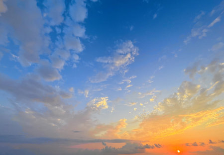 Weather background, sky with clouds. Blue summer sky background with sunset sunの写真素材