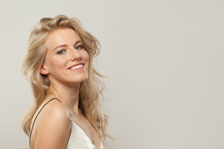 Attractive blond woman with cute smile looking at camera. Beauty young adult person portraitの写真素材