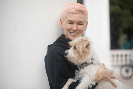 Perfect woman having fun playing with pet dog outdoorsの写真素材