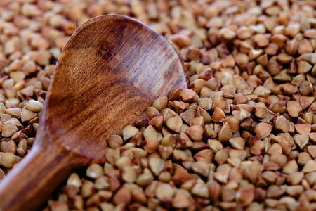 Raw buckwheat grains with wooden cooking spoonの写真素材
