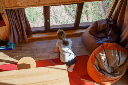 Brunette child girl near the window, top viewの写真素材