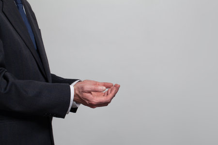 A man in a suit is holding his hands out.の写真素材