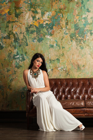 Nice woman with long hair and make-up sitting in vintage luxurious interiorの写真素材