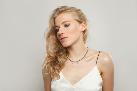 Glamorous blond woman with cute smile looking at camera. Beauty young adult person portraitの写真素材