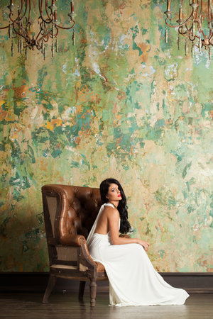 Elegant woman with long hair and make-up sitting in vintage luxurious interiorの写真素材