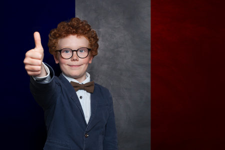 Successful child boy on French flag background. Education, travel, school, camp and study language in France conceptの写真素材