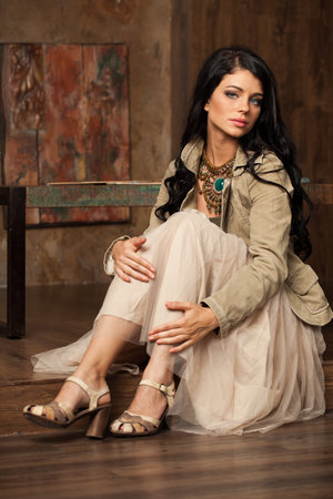 Attractive woman with long hair and make-up sitting in vintage luxurious interiorの写真素材