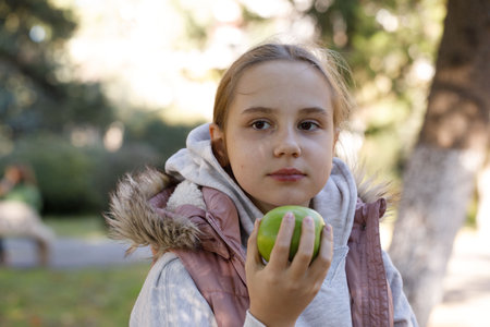 Beautiful child girl walking in city park outdoors. Healthy playful kid portraitの写真素材