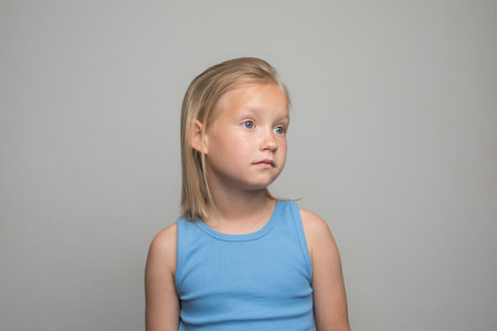 Pretty young child girl standing against white wall backgroundの写真素材