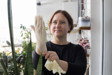 Happy mid adult woman putting on glove ready to gardening. Gardening, relaxation and planting...