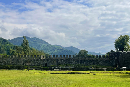 Old wall of Roman Fortress with green grass, blue sky and white clouds. beautiful landscape