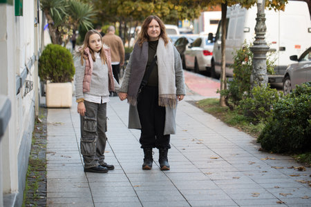 Female family. Woman and young girl child walking along the streets of the city. Childhood, happiness, vacation, family and leisure activity conceptの写真素材