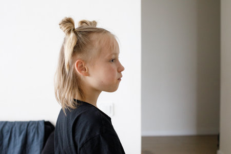 Young child girl standing against white wall background at homeの写真素材