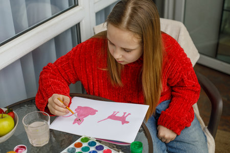 Pretty child drawing pink cats in a sketchbook. Young preteen girl paintingの写真素材