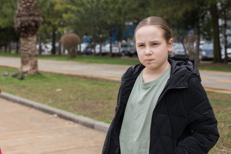 Child little girl in black jacket walking outdoors