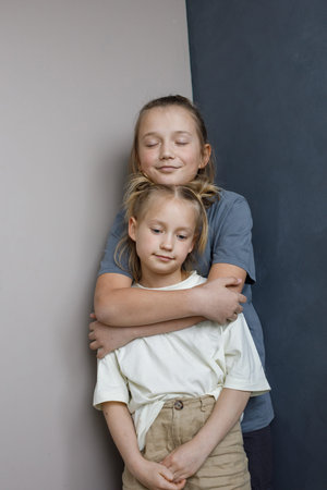 Adorable young sister and brother hugging indoor. Sibling children together portraitの写真素材