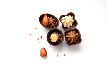 chocolate candies with nuts on a white background photographed from above