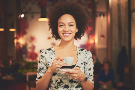 Mixed race woman having a coffee in coffee shopの写真素材
