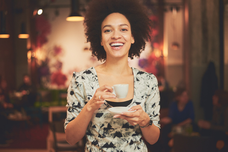 Mixed race woman having a coffee in coffee shopの写真素材